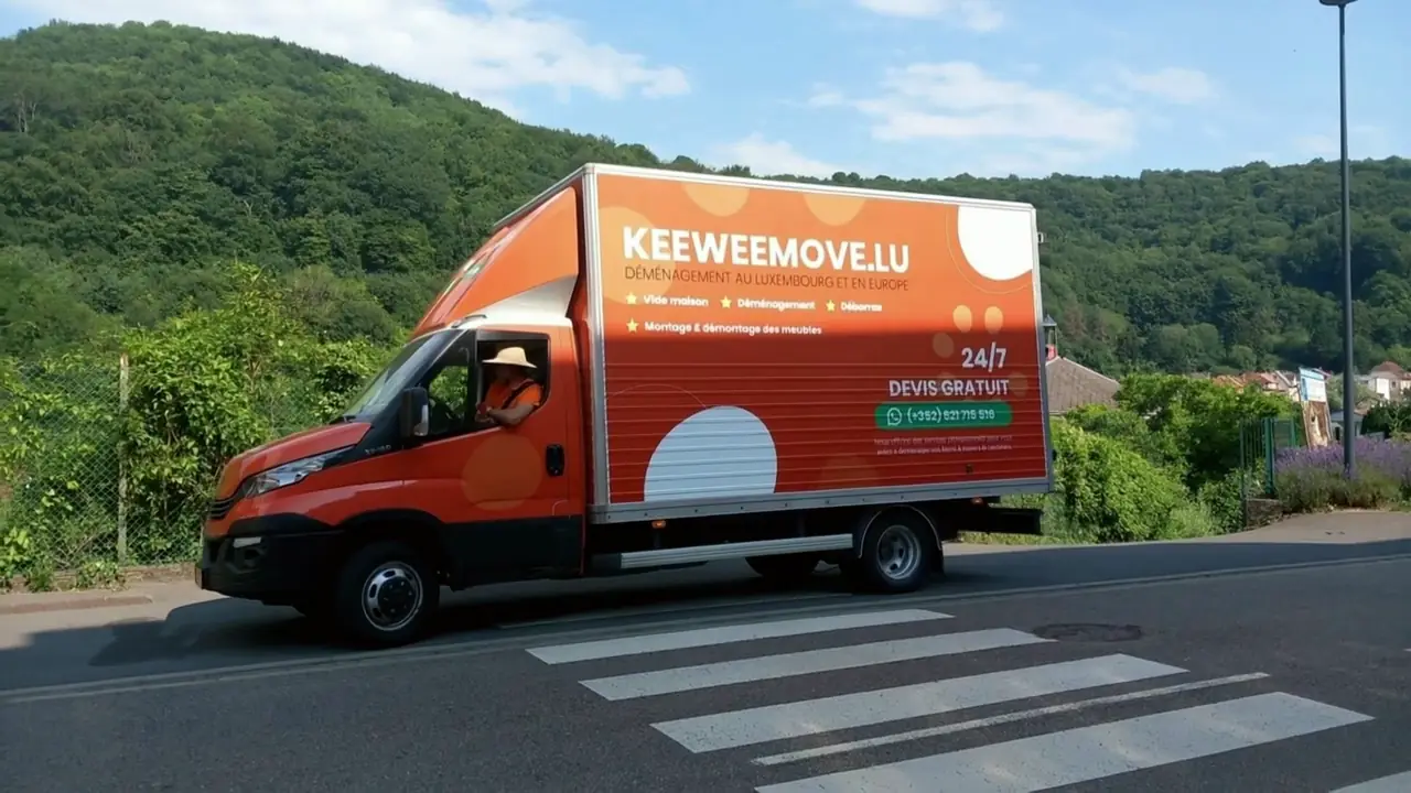 Camion de déménagement KeeweeMove floqué orange sur la route